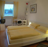 Schlafzimmer mit TV und Schreibtisch